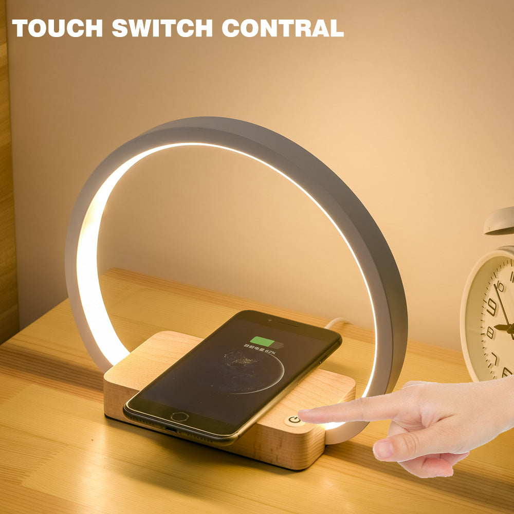 Table lamp with touch switch and wireless charging pad on a wooden surface.
