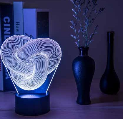 3D heart-shaped light on a table with vases and books in the background
