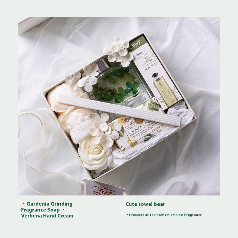 Gifting set with soap, towel, and other items in a decorative box on a white background