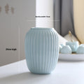 Light blue ceramic bottle with measurements on a neutral background