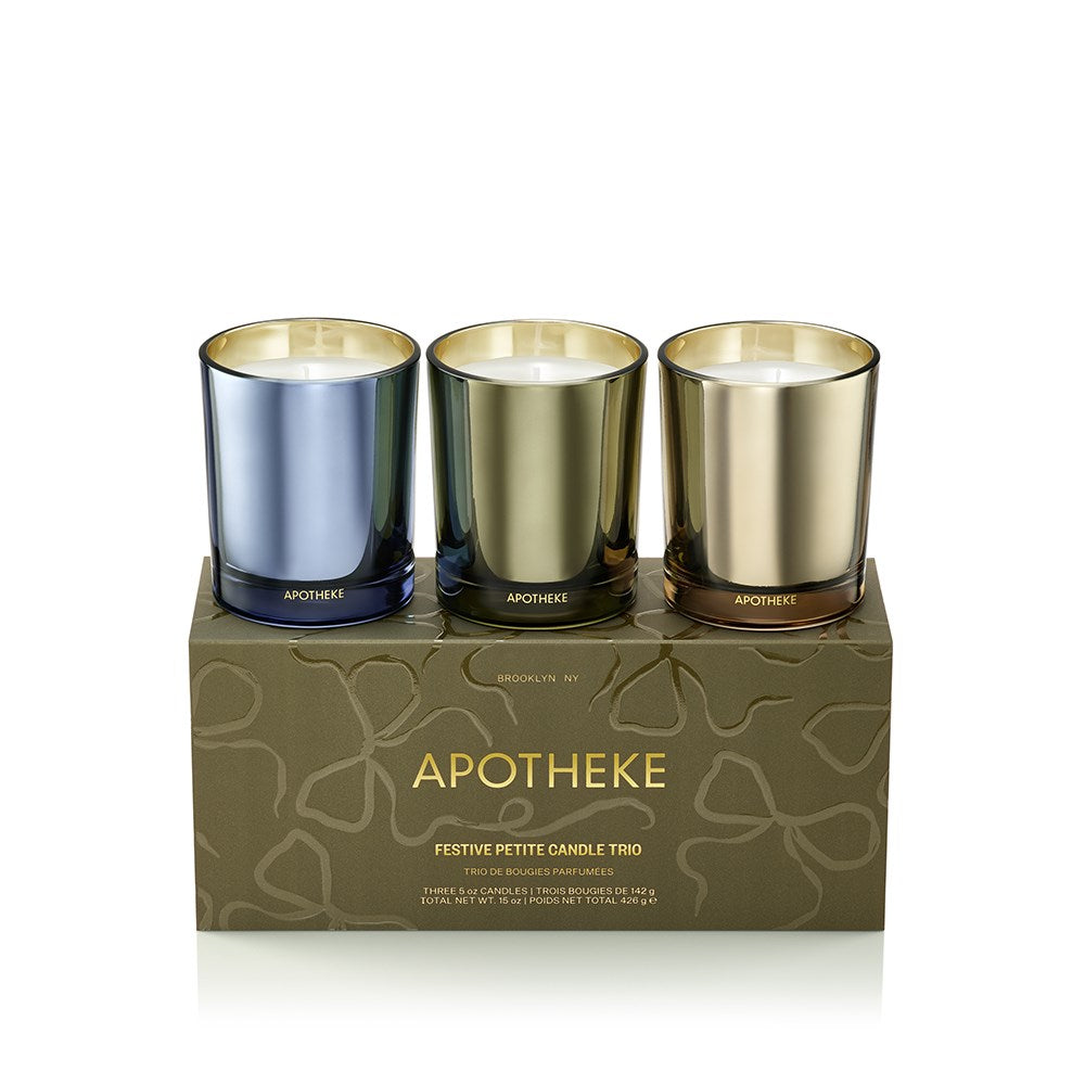 Three small candles in metallic holders on a branded box with 'Apotheke' branding.