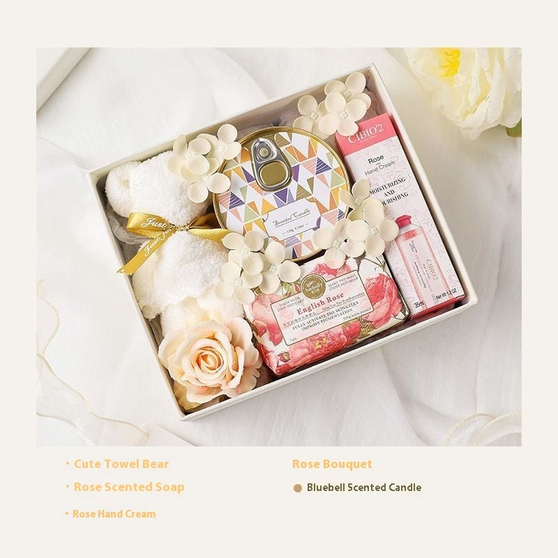 Gift set with a towel bear, soap, candle, and other items in a box on a white background.