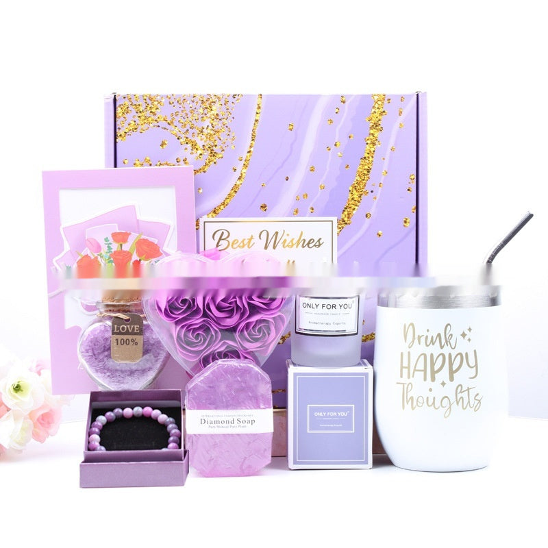 Gifting set with purple and gold elements, including a candle, soap, and tumbler.