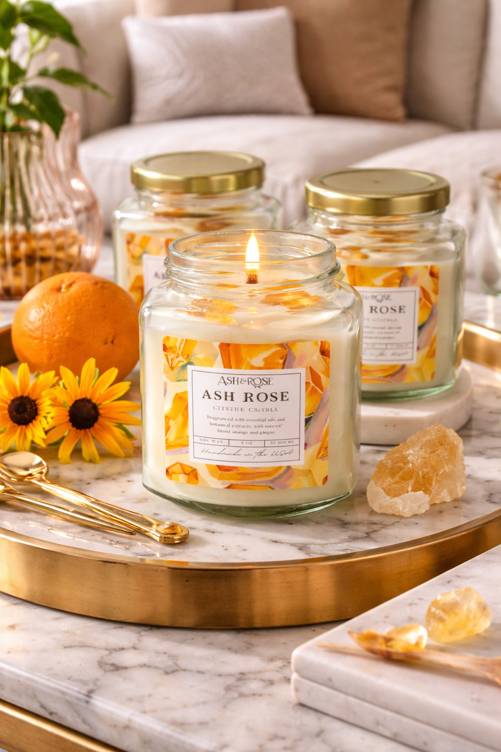 Candle labeled 'Ash Rose' on a marble surface with decorative items.
