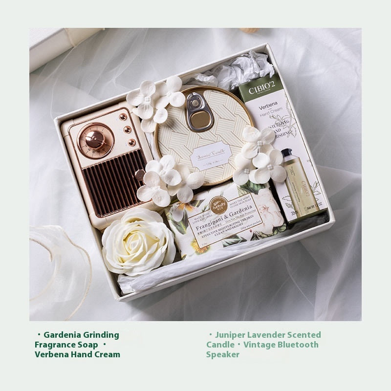 Gifting set with vintage Bluetooth speaker, soap, and other items on a soft fabric background